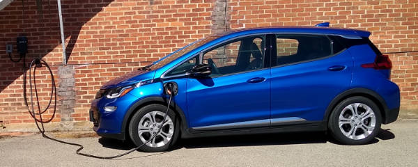 A blue Chevy Bolt being recharged.
